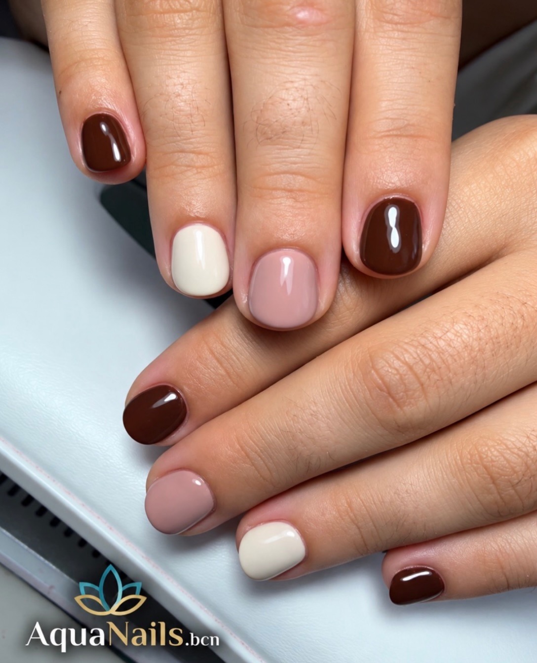 Uñas cortas en tonos marrón chocolate, rosa y crema en diferentes dedos